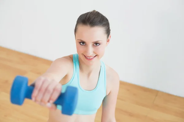 Mujer sonriente con mancuerna en el gimnasio — Foto de Stock