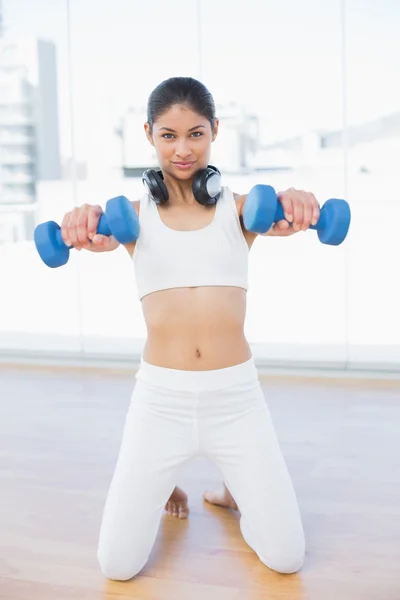 Žena cvičení s činkami v fitness studio — Stock fotografie