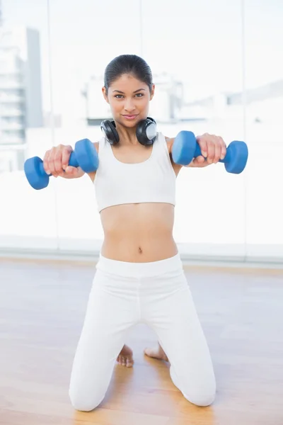 Woman exercising with dumbbells in fitness studio — Stock Photo, Image