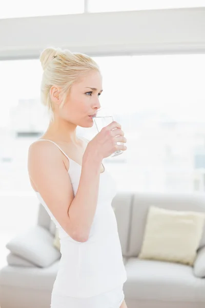 Fit smiling woman with a glass of water at gym — Stock Photo, Image