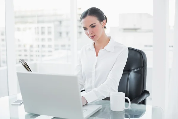 Empresaria concentrada usando laptop en oficina —  Fotos de Stock