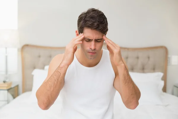 Mann leidet unter Kopfschmerzen im Bett — Stockfoto