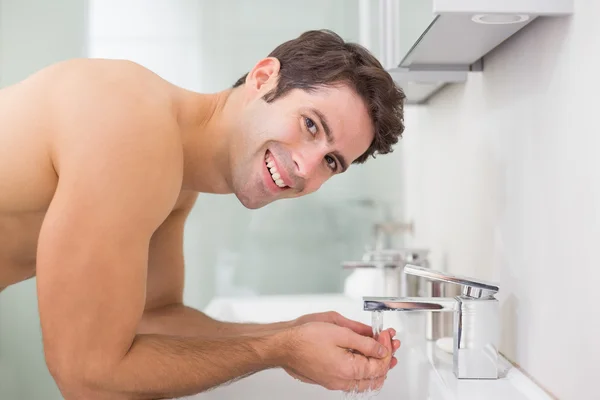 Porträt eines Mannes ohne Hemd, der sich im Badezimmer das Gesicht wäscht — Stockfoto