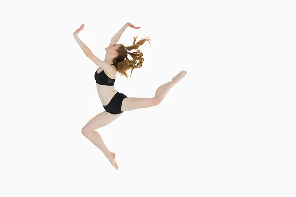 Vista lateral de longitud completa de una mujer deportiva saltando —  Fotos de Stock