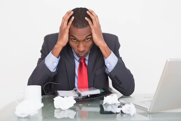 Frustrado hombre de negocios afro con la cabeza en las manos en el escritorio — Foto de Stock