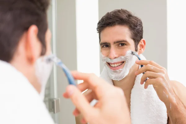 Handsome young man with reflection shaving in bathroom — Stock Photo, Image