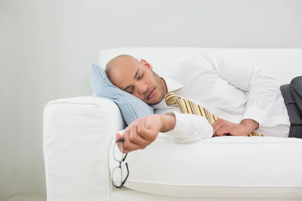 Бизнесмен спит дома на диване — стоковое фото
