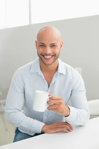 Χαμογελώντας όμορφος άνθρωπος που κρατά το φλιτζάνι καφέ στο σπίτι — Φωτογραφία Αρχείου