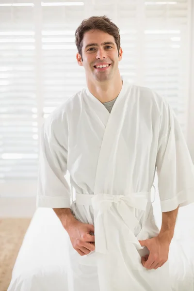 Portret van lachende man in badjas in slaapkamer — Stockfoto