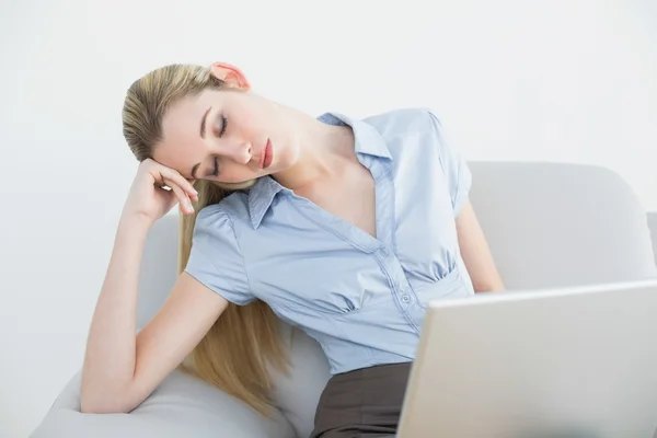 Exhausted ponytailed businesswoman sitting on couch sleeping — Stock Photo, Image