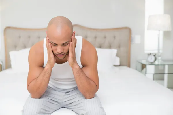 Homem careca que sofre de dor de cabeça na cama — Fotografia de Stock