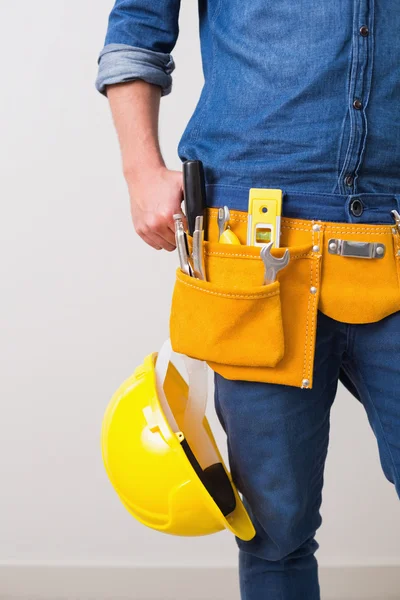 Mitten delen av en elektriker med toolbelt och hjälm — Stockfoto