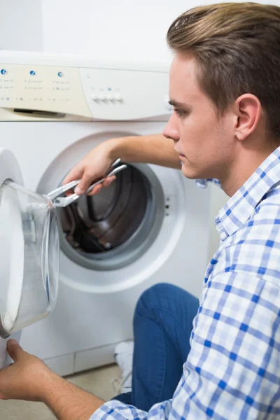 Technicus die een wasmachine repareert — Stockfoto