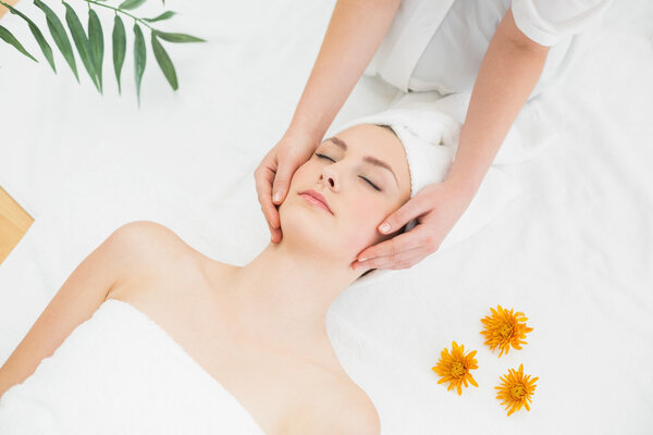 Руки массируют лицо красивой женщины
