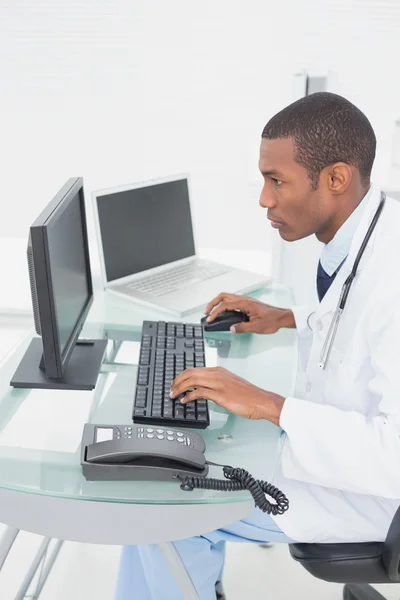 Врач за компьютером в медицинском кабинете — стоковое фото