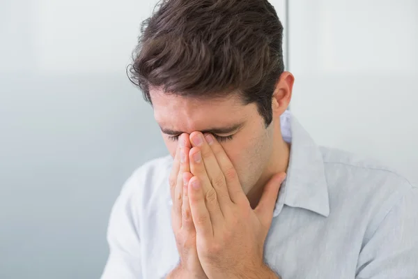 Triest casual jonge man met de handen op zijn gezicht — Stockfoto