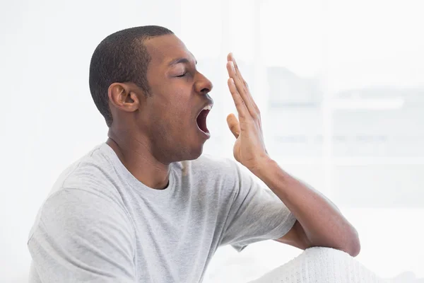 Close up side view of a young Afro man yawning — Stock Photo, Image