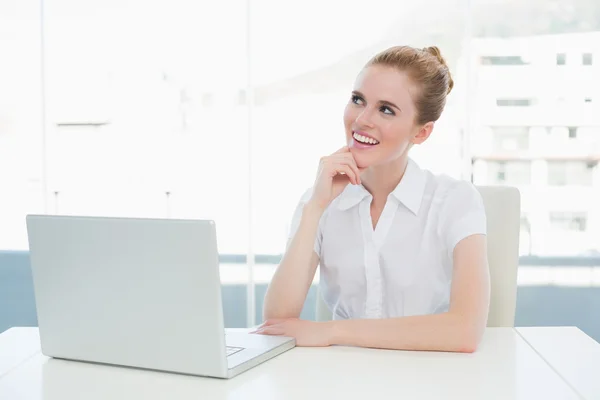 Mujer de negocios mirando hacia arriba mientras se utiliza el ordenador portátil en la oficina —  Fotos de Stock