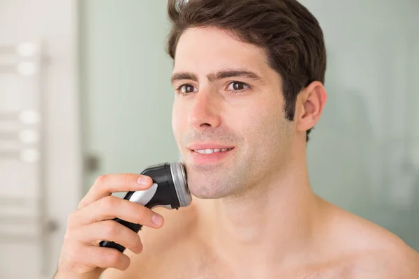 Handsome shirtless man shaving with electric razor — Stock Photo, Image