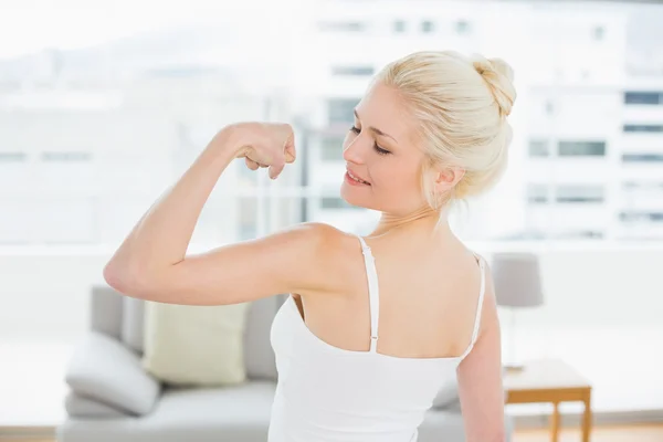 Bakifrån stående vältränad kvinna flexar muskler — Stockfoto