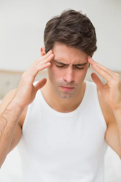 Jeune homme souffrant de maux de tête au lit — Photo