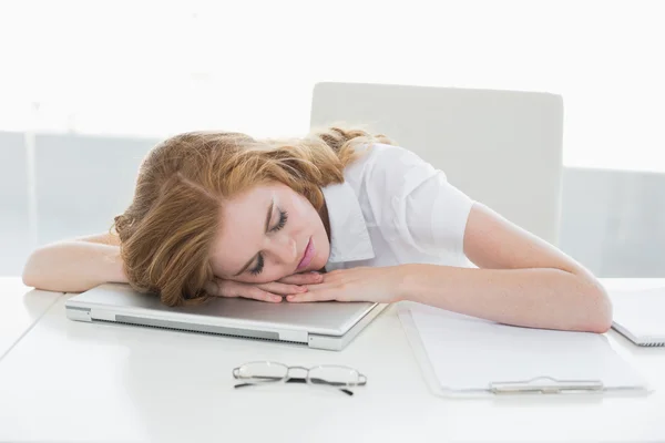 Zmęczona kobieta z głową na laptopie w biurze — Zdjęcie stockowe