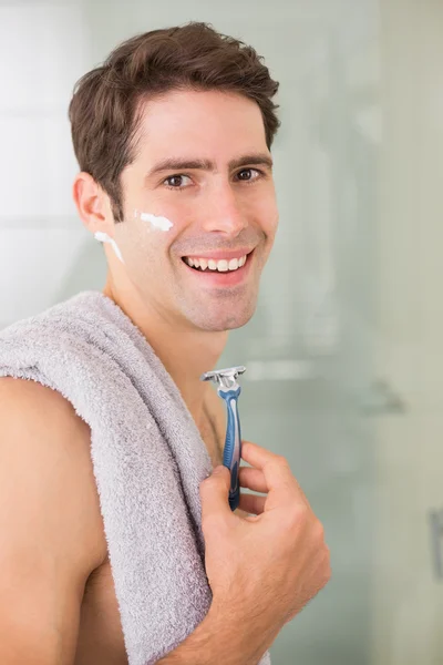 Usměvavý pohledný muž holení v koupelně — Stock fotografie