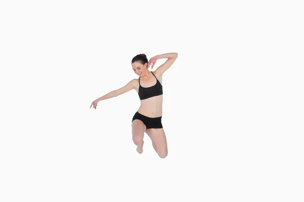 Volledige lengte van een sportieve jonge vrouw springen — Stockfoto