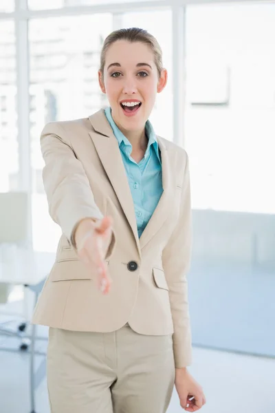 Schicke Geschäftsfrau reicht ihre Hand und lächelt freundlich in die Kamera — Stockfoto