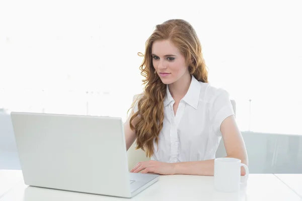 Zakenvrouw drinken van koffie tijdens het gebruik van laptop — Stockfoto