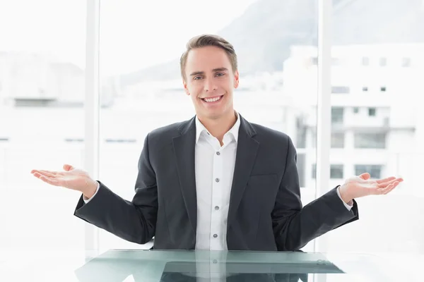 Uomo d'affari sorridente con gesto della mano alla scrivania dell'ufficio — Foto Stock