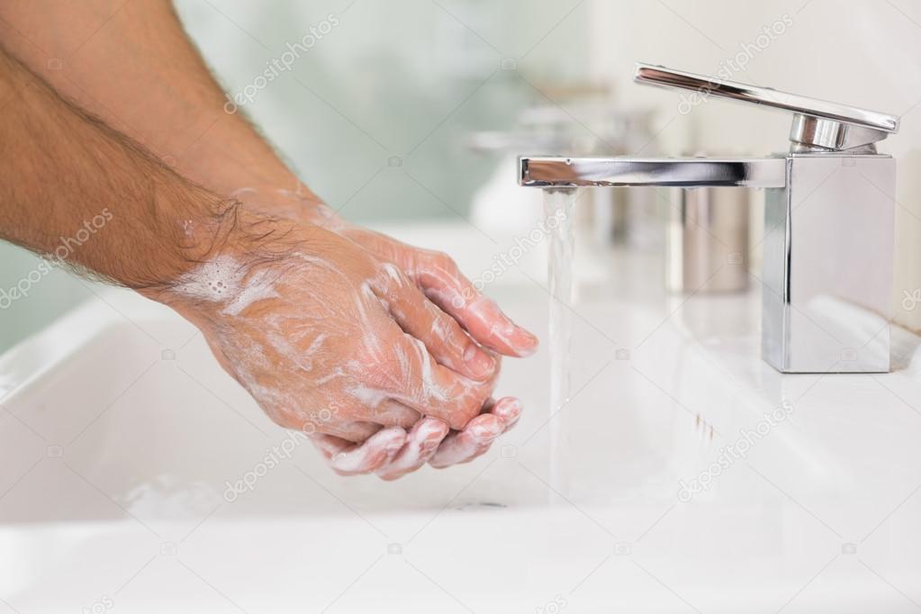 Washing hands with soap under running water