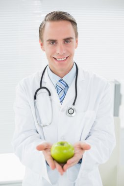 gülümseyen erkek doktor elinde bir yeşil elma