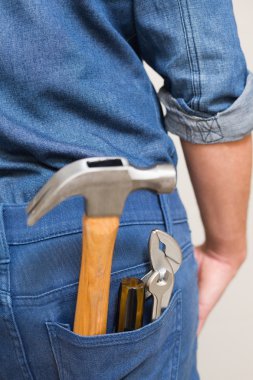 Several tools in a man's rear denim pocket