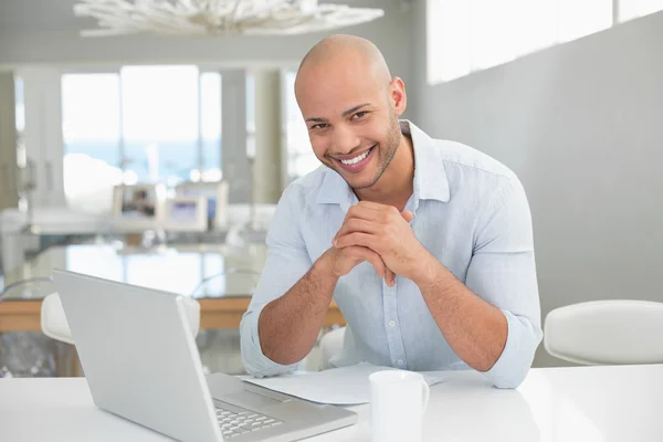 Χαμογελώντας περιστασιακή άνθρωπος χρησιμοποιώντας φορητό υπολογιστή στο σπίτι — Φωτογραφία Αρχείου