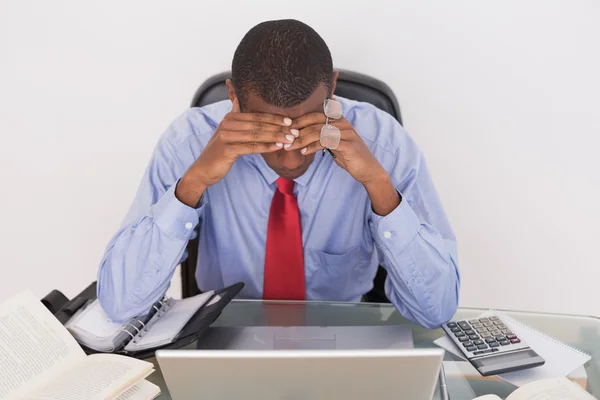 Frustrado hombre de negocios afro con la cabeza en las manos en el escritorio — Foto de Stock