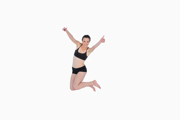 Full length of a sporty young woman jumping — Stock Photo, Image