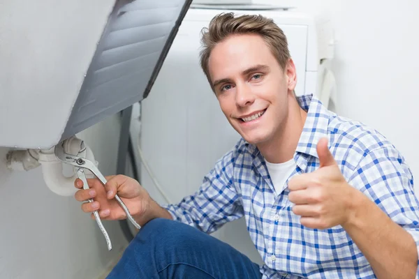 Fontanero reparando el desagüe del lavabo mientras gestiona los pulgares hacia arriba — Foto de Stock