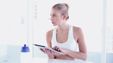 Sportif gülümseyen sarışın tablet kullanma