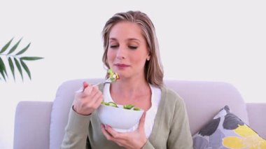 sarışın kadın kanepede oturan salata yemek içerik