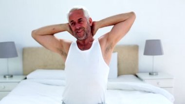 esneme ve germe yatakta otururken yakışıklı adam