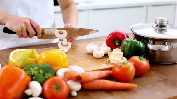 Woman slicing mushrooms on a chopping board — Stock Video