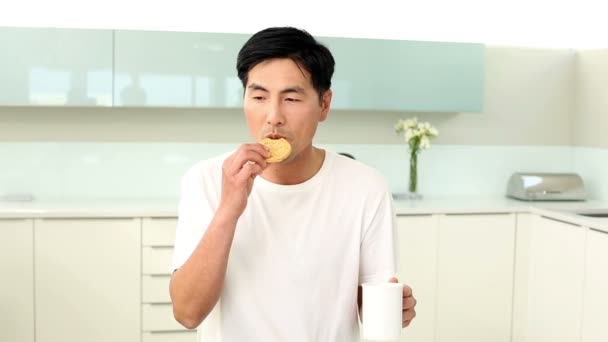 Homem atraente comer biscoito e beber — Vídeo de Stock