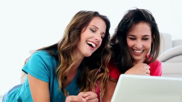 Attrayant amusé les femmes à l'aide d'un ordinateur portable couché sur le sol — Video