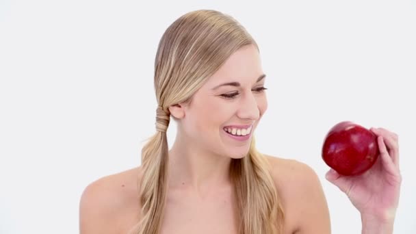 Feliz rubia desnuda sosteniendo manzana roja — Vídeos de Stock