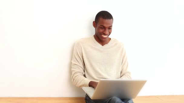 Hombre feliz usando el portátil sentado en el suelo — Vídeos de Stock