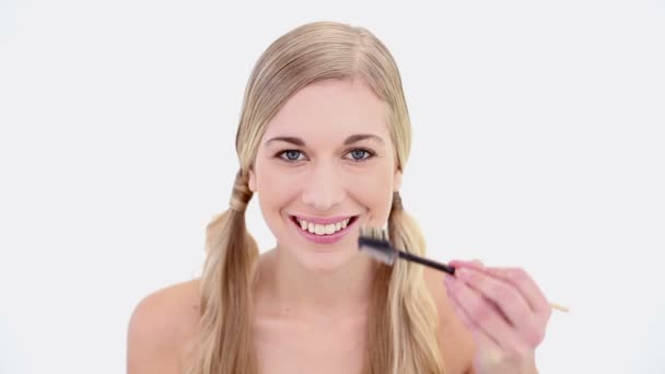 Щаслива оголена блондинка використовує пензлик для брів — стокове відео