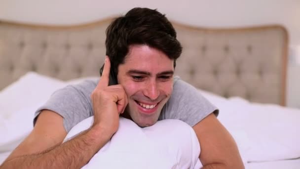 Smiling handsome man phoning in bed — Stock Video