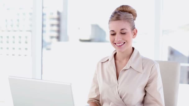 Smiling blonde businesswoman using laptop — Stock Video