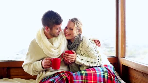 Cute couple relaxing together under a blanket in their ski lodge — Stock Video